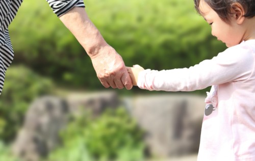 孫の手をにぎる高齢者