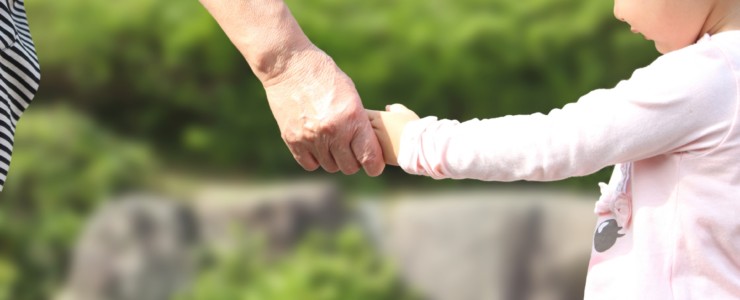 孫の手をにぎる高齢者